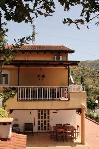 a house with a balcony and a table and chairs at Villa Artemis in Graniti