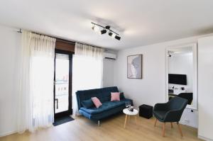 Studio Apartman Dream في رييكا: غرفة معيشة مع أريكة زرقاء وكرسي