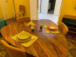 a wooden table with plates and utensils on it at Casa Vacanze Disque Rouge in Trani +24 photos