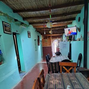 una sala da pranzo con tavoli, sedie e TV di Hostería el Sol Naciente a Tilcara