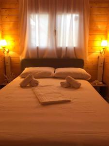 - un lit avec 2 serviettes et une fenêtre dans l'établissement Fillip wooden house, à Prévéza