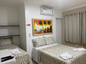 um quarto de hotel com duas camas e uma janela em Pousada La Belle em Maragogi