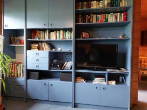 un estante de libros azul con un televisor. en Ferienwohnung Heucke en Berlín