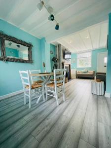 帕克蓋特的住宿－The Rambler's Rest Cottage, Parkgate, Wirral，一间拥有蓝色墙壁和桌椅的用餐室