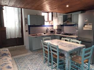 uma cozinha com armários azuis e uma mesa e cadeiras em L'Ancorotto Azzurro em Gaeta