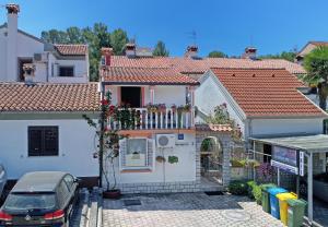 una casa blanca con balcón y un coche en Apartments Rimac 663, en Poreč