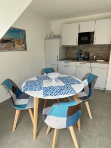 une cuisine avec une table et des chaises ainsi qu'une cuisine avec une table et des chaises dans l'établissement Ferienwohnung Lieblingsplatz-Greetsiel, à Greetsiel