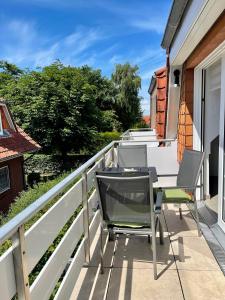 d'une terrasse avec des chaises et une table sur un balcon. dans l'établissement Ferienwohnung Lieblingsplatz-Greetsiel, à Greetsiel