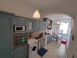 a kitchen with green cabinets and a sink and a table at La Casetta del Bianconiglio con Garage in Genoa