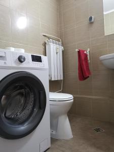 La salle de bains est pourvue d'un lave-linge et de toilettes. dans l'établissement Coffee Residence, à Bucarest