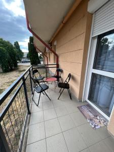 un balcón con sillas y una mesa en una casa en Alina apartmanok, en Hajdúszoboszló