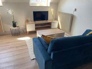 a living room with a blue couch and a tv at La Douce Échappée, 2 Pers, Bien Situé in Boulogne-sur-Mer