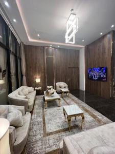 ein Wohnzimmer mit Sofas und einem TV in der Unterkunft الاتحاد الذهبية للشقق المخدومة 2 in Al-Hasa