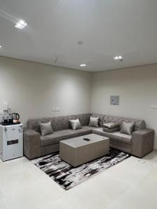 un soggiorno con divano e tavolo di الاتحاد الذهبية للشقق المخدومة 2 a Al Ahsa