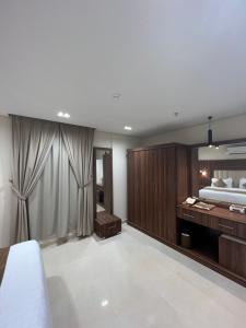 a bedroom with a bed and a vanity and a mirror at الاتحاد الذهبية للشقق المخدومة 2 in Al Ahsa +9 photos