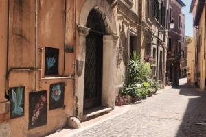 an alley in an old town with a door and plants at Affitto turistico - La Terrazzina in Monterotondo