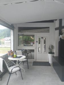 eine Veranda mit einem Tisch und Stühlen sowie eine Küche in der Unterkunft Apartments Krapinske Toplice Krtak Biba in Krapinske Toplice