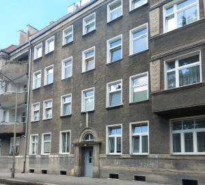 a brick building with white windows on a street at Apartament Mariacka in Nysa