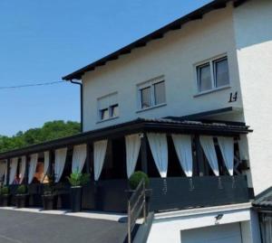 a building with white awnings on the side of it at Apartments Krapinske Toplice Krtak Biba in Krapinske Toplice