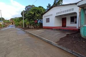 an empty street next to a white building at Casa y Hospedaje Norma in Moyogalpa