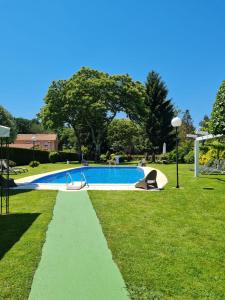 een zwembad in een park met een grasveld bij Casa Rustica Neiro in Santiago de Compostela