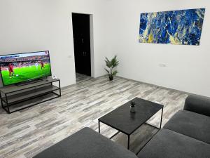 a living room with a tv and a couch and a table at Comfort Apartment in Târgovişte