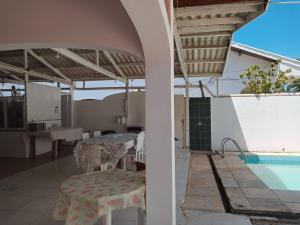 a patio with a table and a swimming pool at Pousada Pérola do Guarujá Ltda- Me in Guarujá