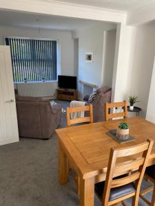 een woonkamer met een houten tafel en stoelen bij Mitchell Heights in Pontnewynydd
