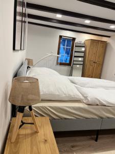 a bedroom with a bed and a table and a mirror at Charmantes denkmalgeschütztes Tiny House am Rhein in Rhens