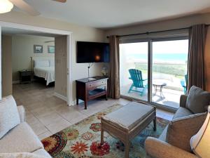 ein Wohnzimmer mit einem Sofa und einem TV sowie ein Schlafzimmer in der Unterkunft Regency Towers 302 West in Pensacola Beach