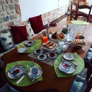 einem Holztisch mit Tellern und Lebensmitteln darauf in der Unterkunft B&b Gaestehaus Tagaro in Locorotondo