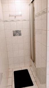 a bathroom with a shower with a black mat on the floor at Budget rooms in Halle with shared bathroom, Free WiFi, Netflix & iPad in Halle an der Saale +30 photos