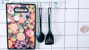 two utensils hanging on a wall with fruits and vegetables at Budget rooms in Halle with shared bathroom, Free WiFi, Netflix & iPad in Halle an der Saale