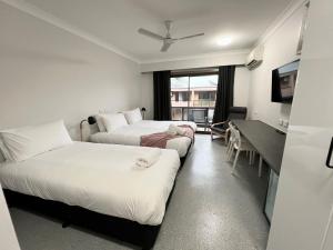 a hotel room with two beds and a desk at Comfort Inn Centrepoint Motel in Lismore