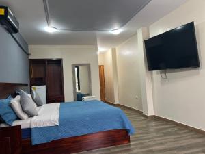 a bedroom with a bed and a flat screen tv at Hotel Berlín International in Puerto López