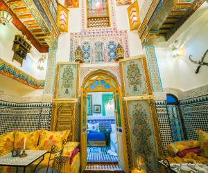 een woonkamer met een kamer met kleurrijke muren en plafonds bij Palais Fes Yahya in Fès al Bali