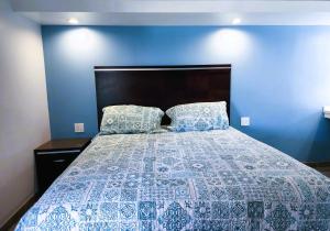a blue bedroom with a bed with a blue wall at DAY N NIGHT INN - Near Universal Studios Hollywood in Los Angeles