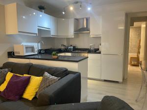 sala de estar con sofá y cocina en Luxe Haven King Bed En-suite & Double with Parking en Londres