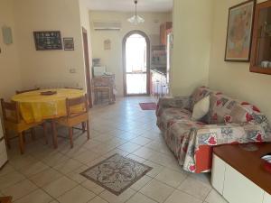 a living room with a couch and a table at Villetta 150mt dalla Spiaggia Flumini di Quartu in Flumini di Quartu