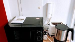 una impresora sentada en la parte superior de un mostrador junto a una licuadora en Room in City Center Halle with shared bathroom & kitchen - Free WiFi, Netflix, iPad & Ground floor, en Halle an der Saale