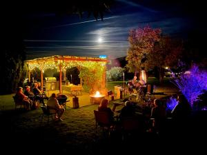 a group of people sitting in chairs in a yard at night at Quirindi Sunflower Motor Inn in Quirindi