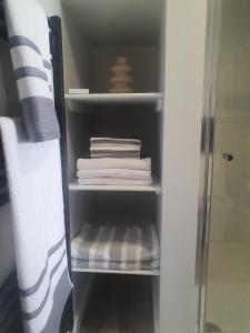 a closet with white towels and a shower at Self catering. Maydene. Holm. Orkney, Scotland. in Nether Button