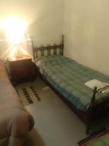 a bedroom with a bed and a table and a lamp at Amancay in Payogasta