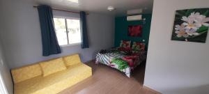 - un salon avec un canapé et un lit dans l'établissement Rangi Pearl Lodge, à Avatoru