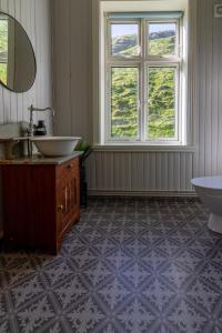 a bathroom with a sink and a tub and a window at Feriehus med flott havutsikt ved Hauklandstranden in Leknes