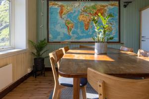 a table in a room with a world map on the wall at Feriehus med flott havutsikt ved Hauklandstranden in Leknes