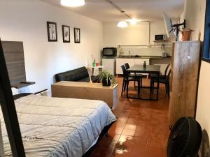 a living room with a bed and a dining room at Departamento privado en Casa Barranca Yaco in Córdoba