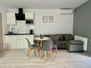 a kitchen and a living room with a table and chairs at Apartamenty Avia - Energylandia Zator in Spytkowice