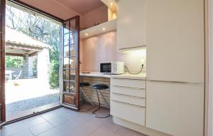 a kitchen with a counter with a microwave and a window at Cozy Home In Roquefort-Les-Pins in Roquefort-les-Pins