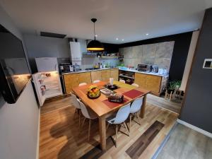 uma cozinha com uma mesa de madeira com cadeiras e uma cozinha com em Casa Magallanes em Ushuaia